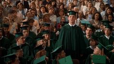 a large group of people wearing graduation caps and gowns in front of a crowd