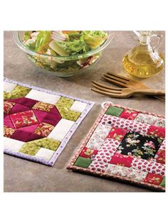 a bowl of salad next to two quilted placemats and a glass dish holder