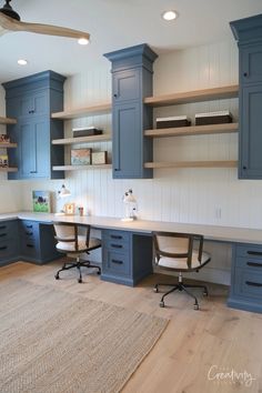 a home office with blue cabinets and desks in the center, along with an area rug on the floor