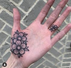 a person's hand with a flower tattoo on the middle of their left palm