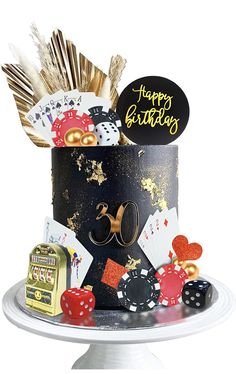 a casino themed birthday cake with cards, dices and other items on a plate