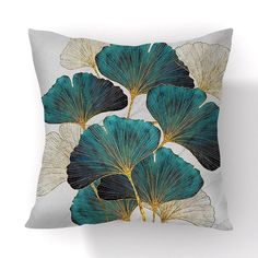 a blue and white pillow with gold leaves on it