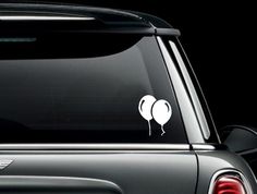 an apple decal is on the back of a mini cooper hatchback car window