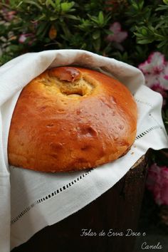 a loaf of bread sitting on top of a white napkin next to some pink flowers