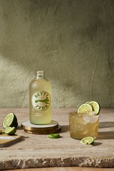 a bottle of gin on a table with limes