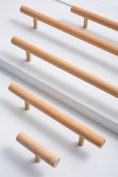 three pieces of wood sitting on top of a white surface