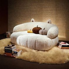 a large white couch sitting on top of a shaggy rug next to a book shelf