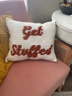 a crocheted pillow sitting on top of a pink chair