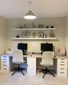 a home office with two computer desks and white chairs in front of shelves on the wall