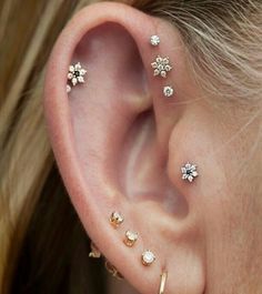 an image of a woman's ear with some piercings on it