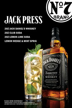 a bottle of jack daniels whiskey next to a glass filled with lemon wedge and mint