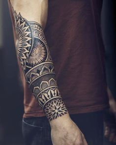 a man's arm with an intricate tattoo design on the left side of his arm