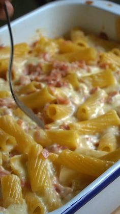 a person is spooning some food out of a casserole dish with cheese and ham