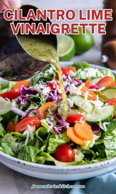 a person pouring dressing onto a salad in a white bowl with lettuce, carrots and cucumbers