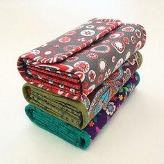 four pieces of cloth stacked on top of each other in different colors and patterns,