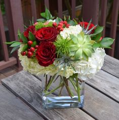 a glass vase filled with red and white flowers