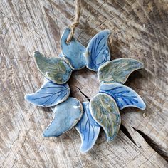 a ceramic flower ornament hanging on a piece of wood