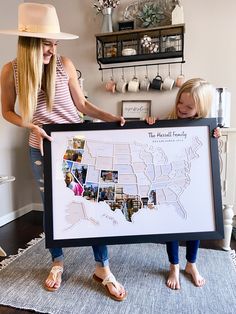 two women holding up a large framed map with pictures on it and the words, the beautiful family