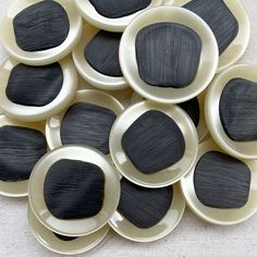 black and white plates are stacked on top of each other in the shape of circles