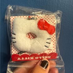 a hello kitty doll with a red bow on it's head in a plastic bag