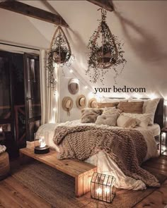 a bed with pillows, blankets and lights in a room that has wood floors and white walls