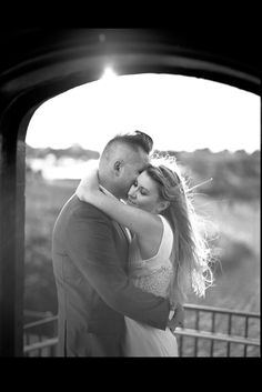 a man and woman embracing each other in black and white