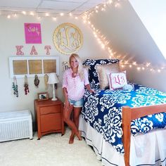 a woman sitting on top of a bed next to a night stand with lights above it