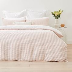 a bed with white sheets and pillows in a room