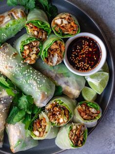 a plate filled with rolls covered in lettuce and sauce