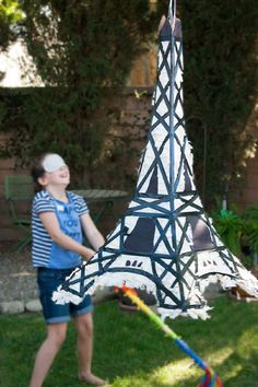 a young boy playing with a kite in front of the eiffel tower