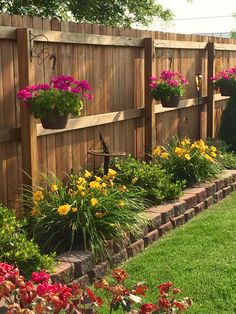 a wooden fence with flower pots on it and flowers growing in the planter boxes