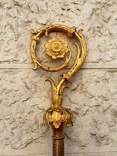 an ornate gold clock on the side of a wall