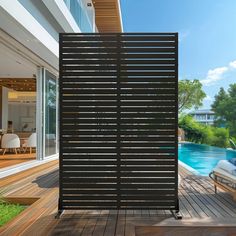 a wooden deck next to a swimming pool with an outdoor privacy screen on the side