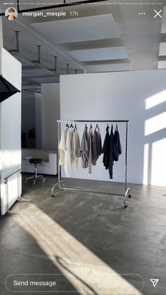 an empty room with clothes hanging on racks