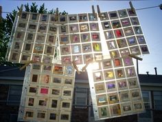 there are many pictures hanging on the clothes pegs in front of a house that has been decorated with photos