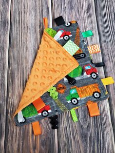 an oven mitt with cars and trucks on it sitting on top of a wooden table