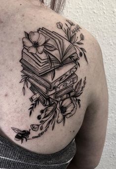 the back of a woman's shoulder with books and flowers on it