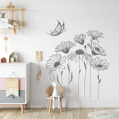 a child's room with white walls and flowers on the wall