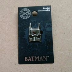 a batman pin with the logo on it's front and back side, sitting on top of a card