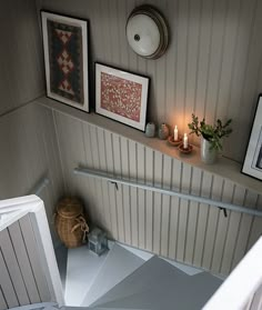 a staircase with pictures and candles on the wall