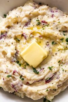 a white bowl filled with mashed potatoes and butter