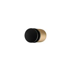 a black and gold knob on a white wall