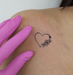 a woman's arm with a small tattoo on the back of her left shoulder