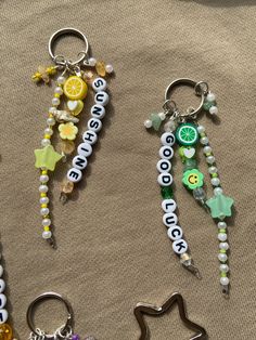 four different key chains with charms attached to them on a cloth covered surface, one has a star and the other has a lemon slice