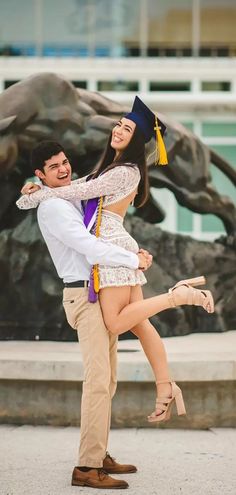 a man holding a woman on his back in front of a statue