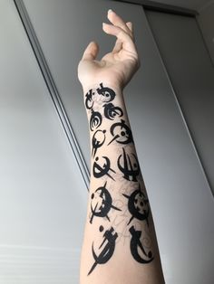 a person's arm with black and white tattoos on it