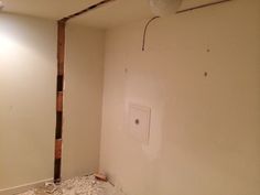 an unfinished room with white walls and exposed electrical wires on the wall next to it