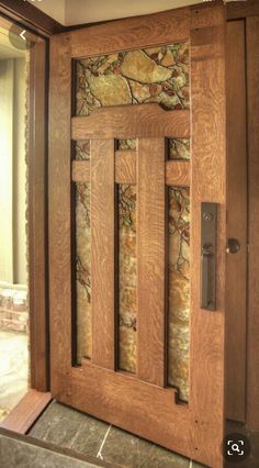 a wooden door with stone panels on the side and glass inserts in the front