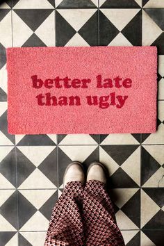 someone standing in front of a rug that says better late than ugly