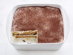 a cake in a white dish with a piece missing